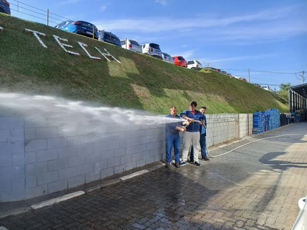 Teste de vazão em hidrante, com o jato de água ao longo do muro