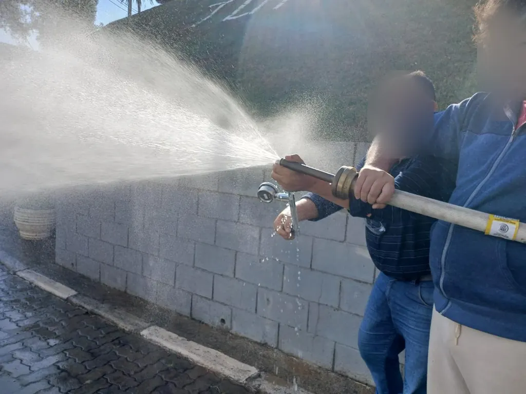 Dois técnicos segurando a mangueira durante o teste do hidrante