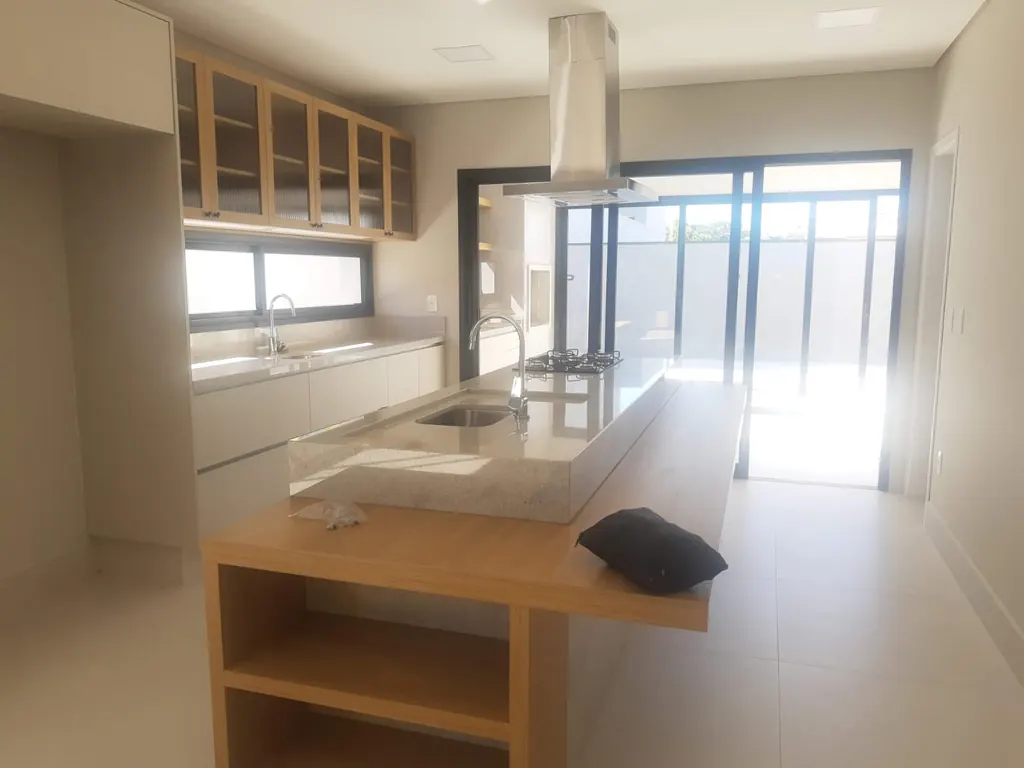 Cozinha com ilha e coifa em residência entregue