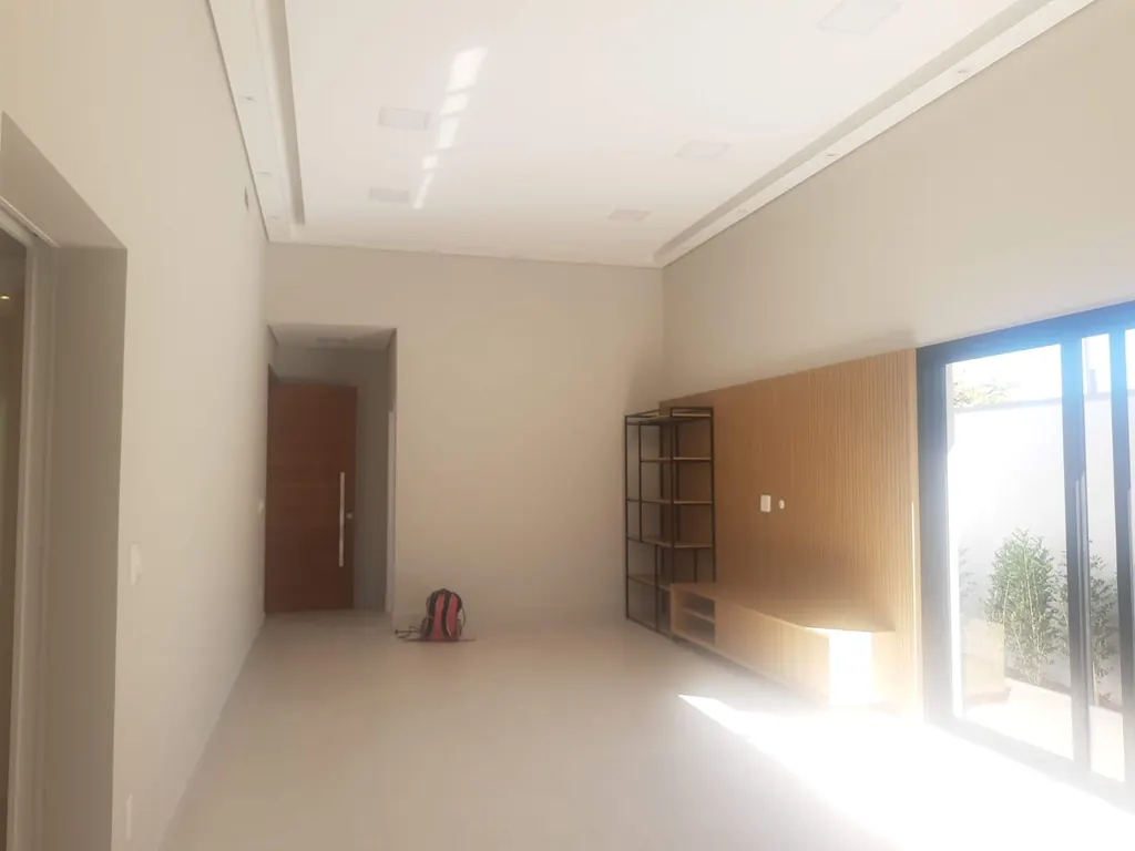 Sala ampla com painel de madeira e portas de vidro