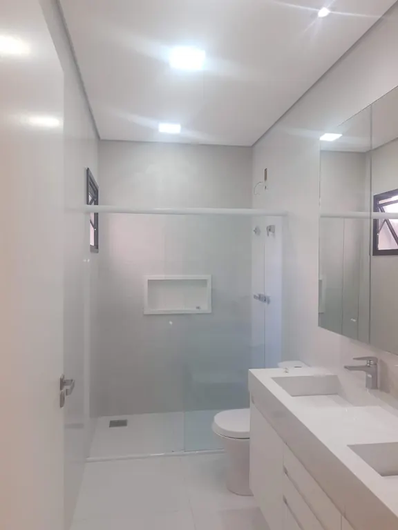 Banheiro com box de vidro e bancada dupla
