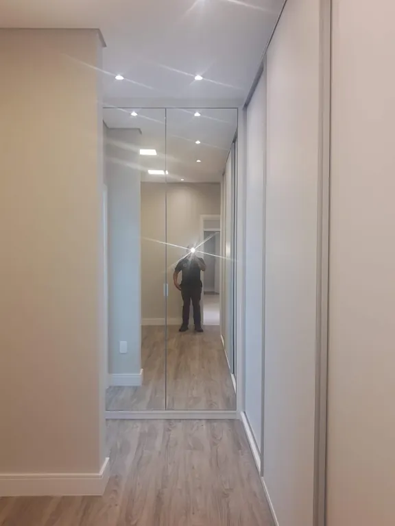 Corredor com armários espelhados e piso vinílico