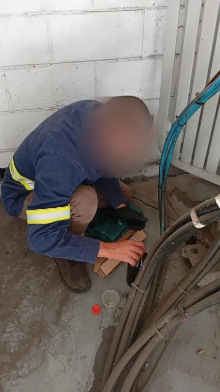 Eletricista agachado conectando cabos de alimentação