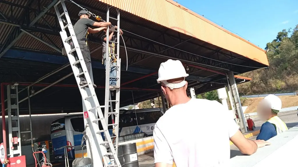 Técnicos de capacete acompanhando a instalação da linha de vida
