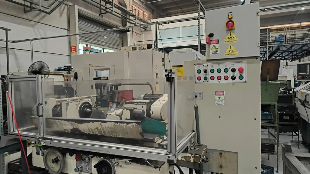 Máquina industrial com proteções e painel com botões de emergência