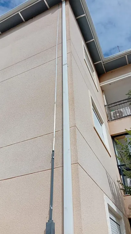 Cabo de descida do SPDA fixado na fachada de prédio residencial