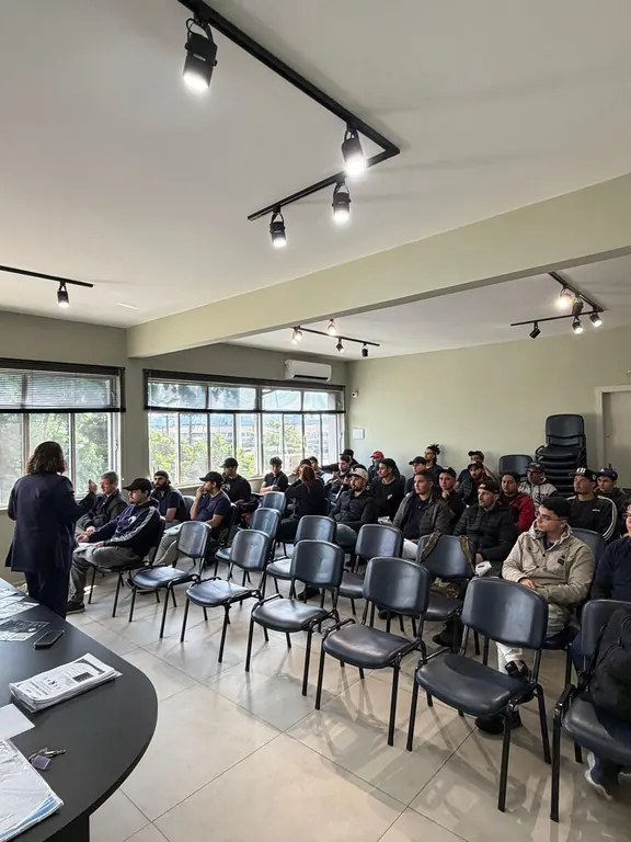 Turma em sala de treinamento, com a instrutora à frente