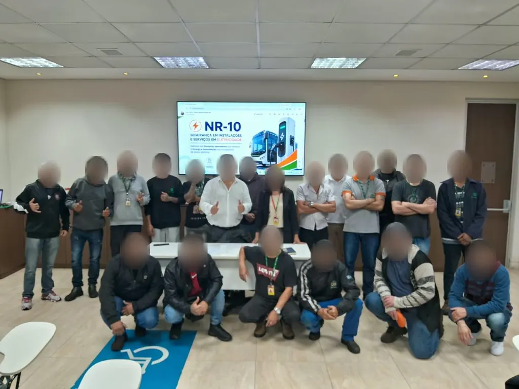 Turma do treinamento de NR-10 reunida em frente à projeção