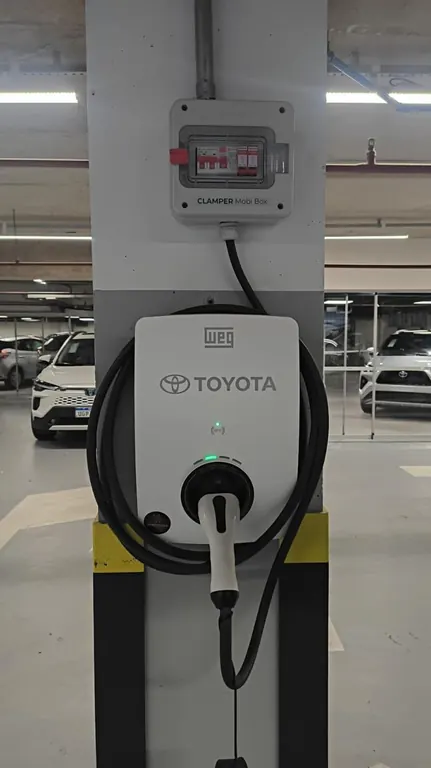 Carregador de veículo elétrico instalado em pilar de garagem, com quadro de proteção acima