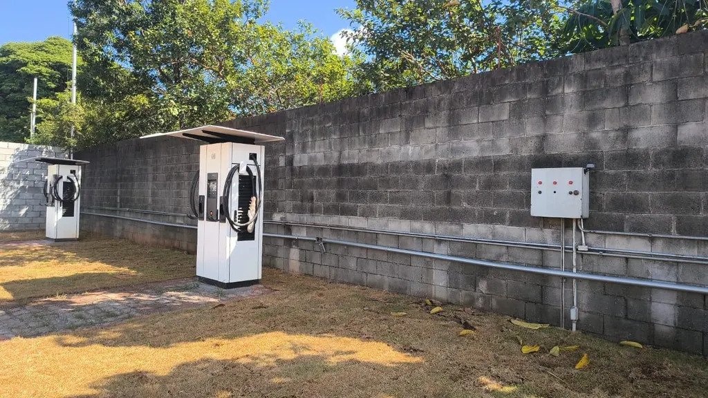 Carregadores de veículos elétricos instalados em área externa, junto ao muro